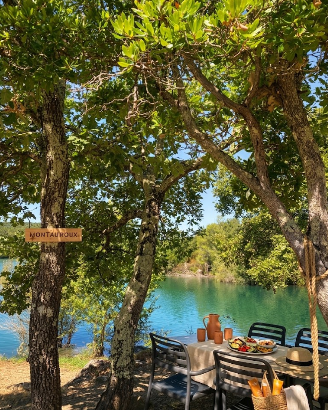 Table dressée à l'ombre des arbres face au lac